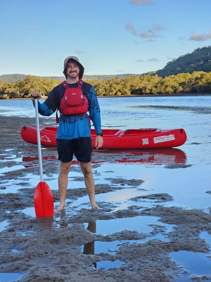 Sam from SNDY Tracks with a canoe on a Central Coast estuary